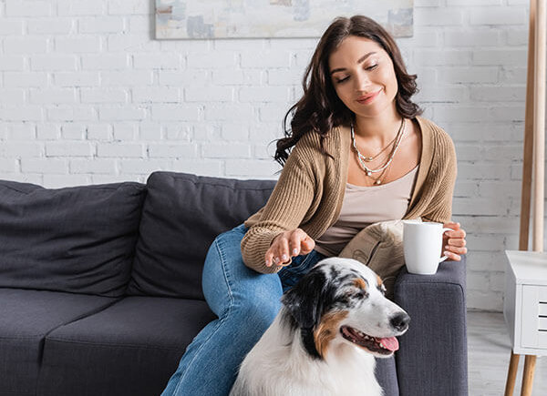 Happy woman petting her dog | Winter Garden Wellness