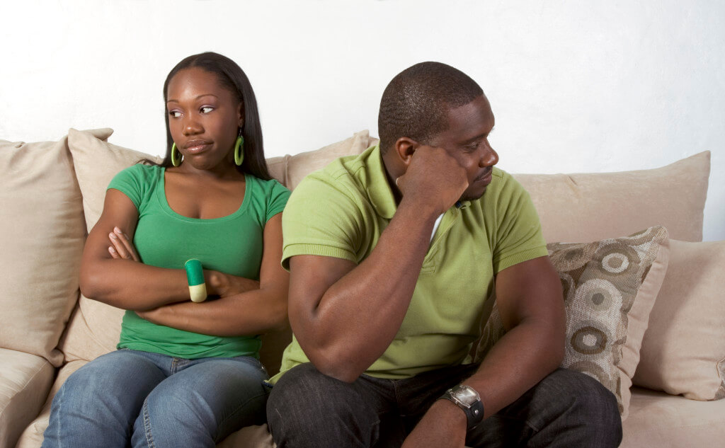 Young black ethnic African-American couple at odds and bad mood not talking with each other and looking away after heated argument is causing problems in marriage