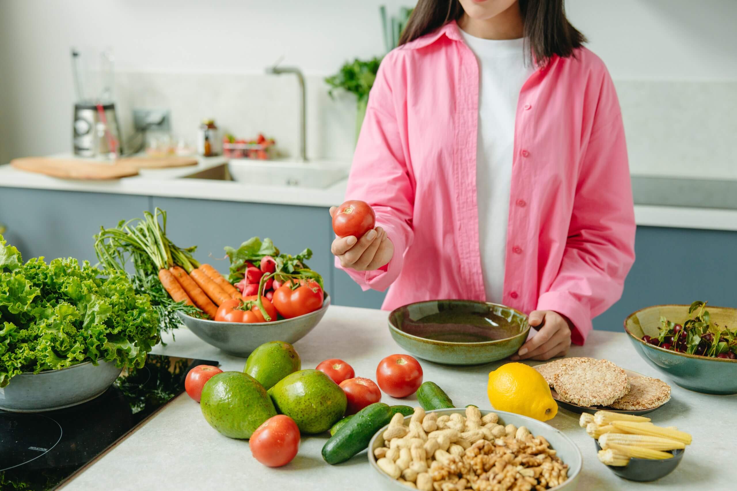 Women's Health | Woman preparing fresh fruits and vegetables for proper diet and wellness.