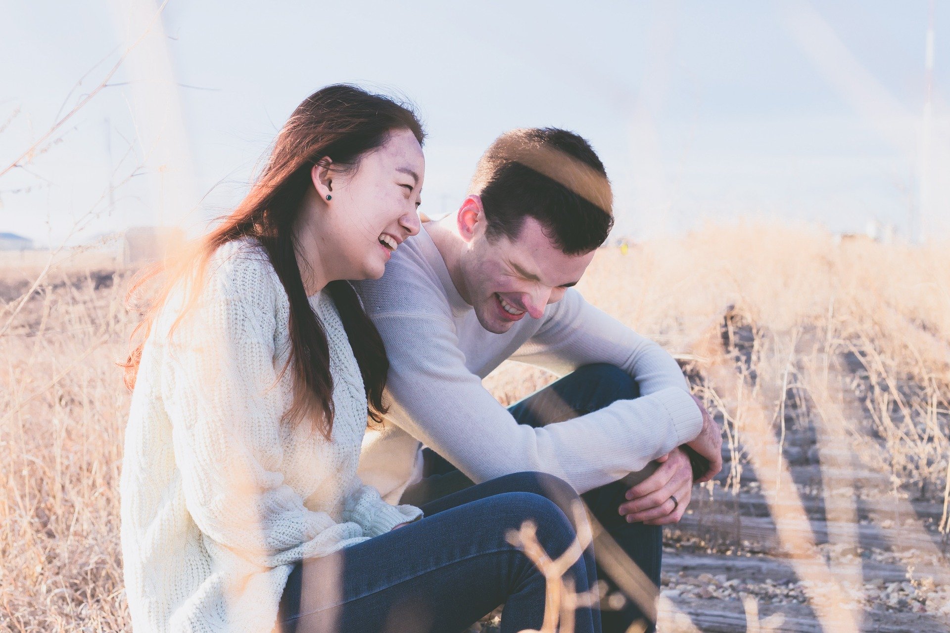 married couple sitting in a field