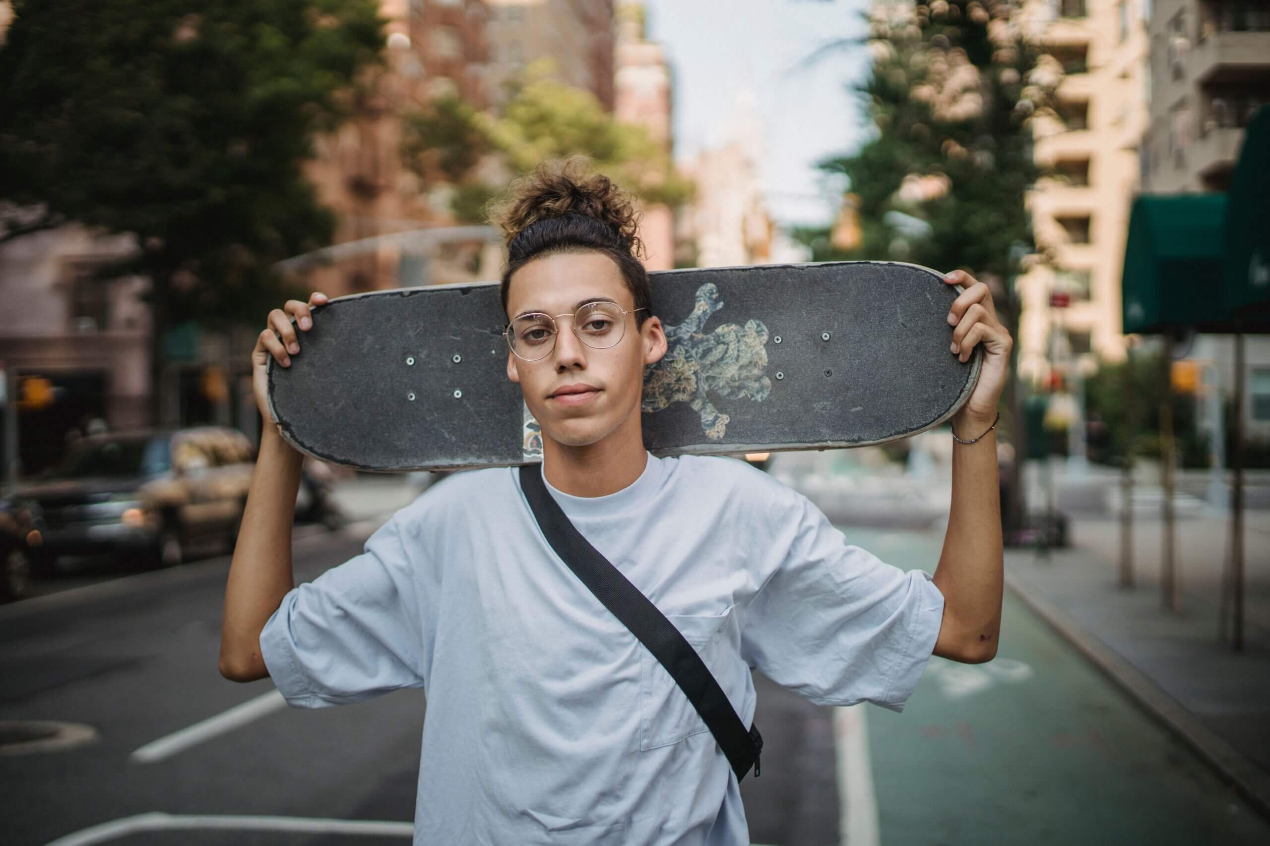 Young teenage man holding a skateboard | Men's counseling
